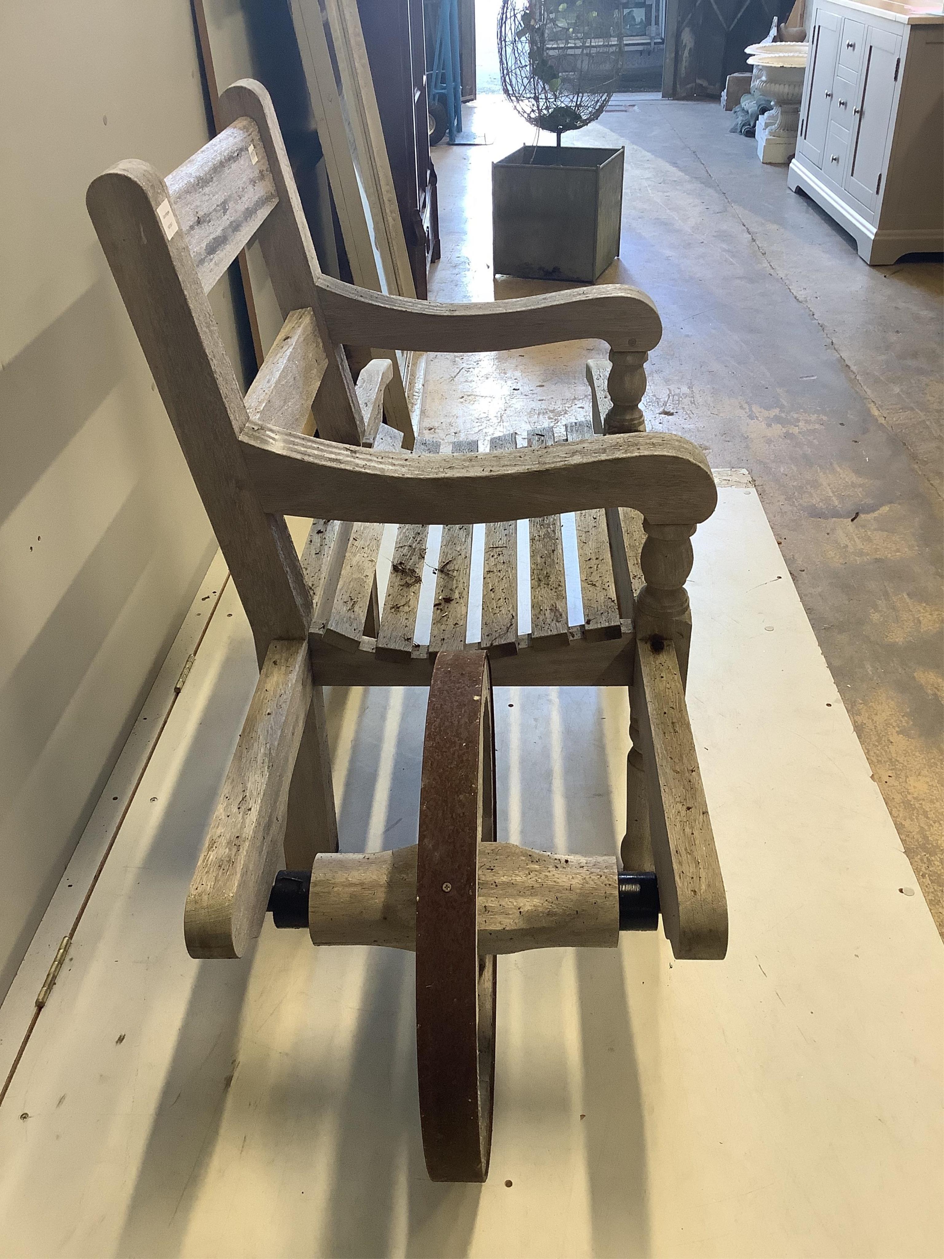 An Andrew Crace weathered teak wheel barrow garden bench. width 166cm, depth 58cm, height 96cm. Condition - fair to good